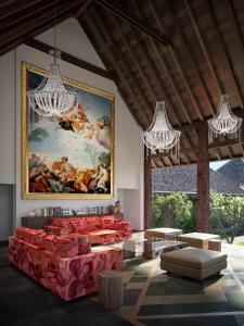 a room with a painting on the wall and red couches at La Reserve 1785 Canggu Beach in Canggu