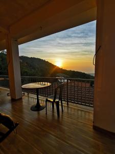 a balcony with a table and a view of the sunset at The SKYi County Dapoli in Dapoli