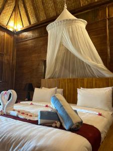 a bedroom with a bed with a canopy at Unzipp Bungalows Gili Air in Gili Air