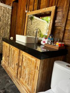 bagno con lavandino e specchio di Unzipp Bungalows Gili Air a Gili Air