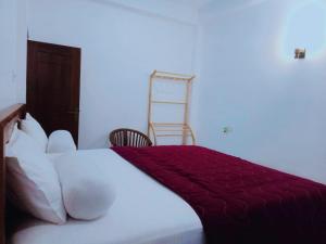 a bedroom with a bed with a red blanket on it at NEW SEA LION Guest House in Hikkaduwa