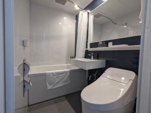uma casa de banho com um WC branco e um lavatório. em Green Rich Hotel Tokuyama Ekimae em Shunan
