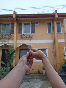 une personne tenant la main devant une maison dans l'établissement Pagadian Staycation in Camella 3, à Pagadian