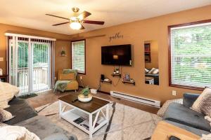 a living room with a couch and a tv at Chalet with Hot Tub near Lake, Pool and Beach in Albrightsville