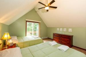 a bedroom with two beds and a ceiling fan at Chalet with Hot Tub near Lake, Pool and Beach in Albrightsville