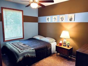 a bedroom with a bed and a ceiling fan at Chalet with Hot Tub near Lake, Pool and Beach in Albrightsville