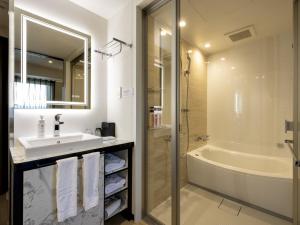 uma casa de banho com um lavatório, um chuveiro e uma banheira em Green Rich Hotel Tokuyama Ekimae em Shunan