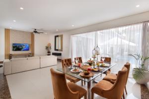 a dining room and living room with a glass table and chairs at The Luxury Collection, Monaco Blu in Seminyak