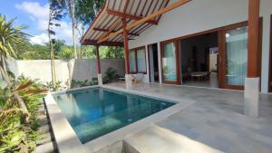 クタにあるKaryana Villa 1の家の前にプールがある家