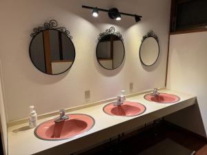a bathroom with two sinks and two mirrors at HAKUBA76 in Hakuba