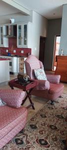 a living room with two chairs and a coffee table at Driftwood Beach Villa in Gordonʼs Bay +21 photos