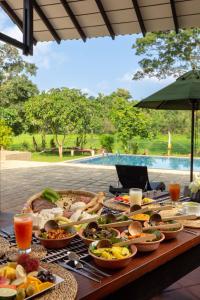 una mesa con muchos platos de comida. en Villa Mankani, en Dambulla