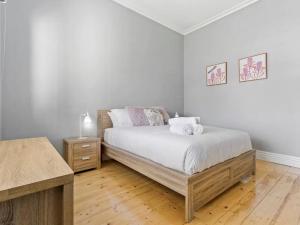 a bedroom with a bed and a wooden floor at NEW! Stunning 4BR Cottage In The Heart Of Ballarat - PET FRIENDLY & FAST WIFI in Ballarat