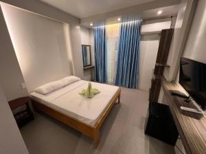 mały pokój z łóżkiem i telewizorem w obiekcie Casi Verde Arc Homes w Panglao City