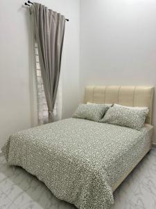 a bed in a white room with a window at Homestay Rumi in Machang