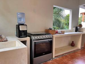 una cucina con piano cottura e frullatore sul bancone di A Son de Mar - Playa Las Gatas acceso por mar a Zihuatanejo
