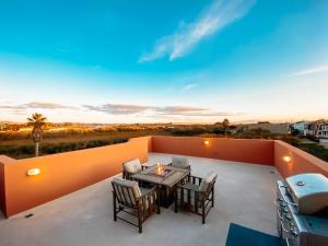 Un patio con una mesa y sillas en un tejado. en Steps to the Beach! Rooftop Deck! Firepit & BBQ!, en Oceano