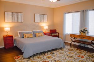 Un dormitorio con una cama, un escritorio y ventanas. en Steps to the Beach! Rooftop Deck! Firepit & BBQ!, en Oceano