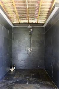 a shower in a room with a black wall at Bungalow Bali Hai in Fare