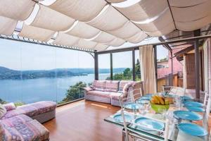 ein Wohnzimmer mit einem Tisch und Blick auf das Wasser in der Unterkunft Villa Arona in Arona