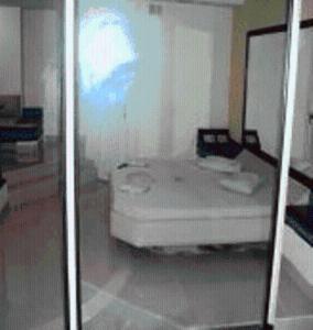 a white room with a bed and a mirror at Lips Motel (Adult Only) in Rio de Janeiro
