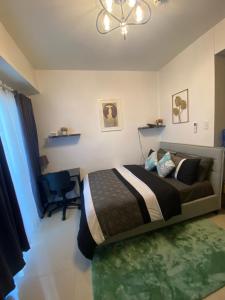 a bedroom with a bed and a chair in it at Cozy and Convenient studio unit @ Inspiria condominium in Davao City