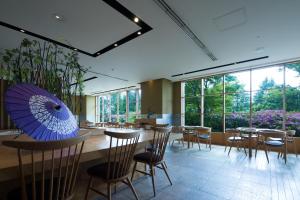 富士吉田的住宿－海蘭德水療度假酒店，一间带桌椅和蓝伞的餐厅
