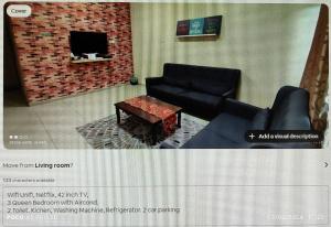 a living room with two black couches and a tv at Sorry Blocked Account 2 in Temerloh