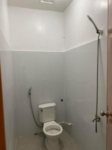 een witte badkamer met een toilet en een douche bij DONQUE'S MOUNTAIN RESORT (D'HORIZON) in Samboan