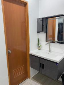 een badkamer met een wastafel en een spiegel bij DONQUE'S MOUNTAIN RESORT (D'HORIZON) in Samboan
