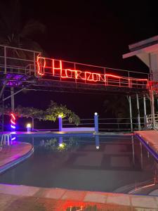 una señal de neón sobre una piscina por la noche en DONQUE'S MOUNTAIN RESORT (D'HORIZON), en Samboan