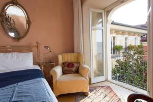 ein Schlafzimmer mit einem Bett, einem Stuhl und einem Fenster in der Unterkunft Pallanza apartment in Verbania