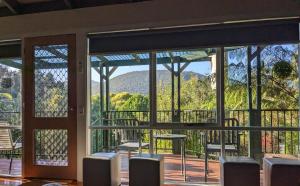 a room with a view of the mountains through windows at Littlehurst Lodge in Millgrove