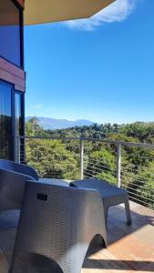 einen Tisch und Stühle auf einem Balkon mit Aussicht in der Unterkunft Casa de montaña Arisa in Cartago