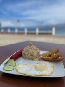 ein Teller mit Eiern und Fleisch am Strand in der Unterkunft Manalo's Lodge and Restaurant in Puerto Galera