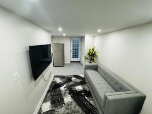 a living room with a couch and a refrigerator at C&M Beautiful Basement in Brampton