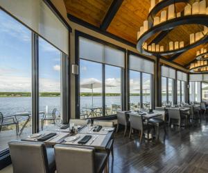 a dining room with tables and chairs and a view of the water at Rodd Miramichi in Miramichi
