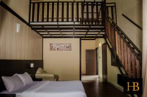 a bedroom with a bed and a staircase at H Benjamin Residence in Kampong Kundassan