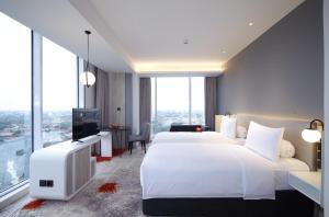 Postel nebo postele na pokoji v ubytování HARRIS Hotel & Convention Cibinong City Mall Bogor