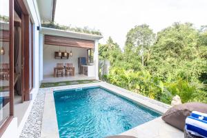 a swimming pool in the backyard of a house at Jenar Ubud Villa in Ubud