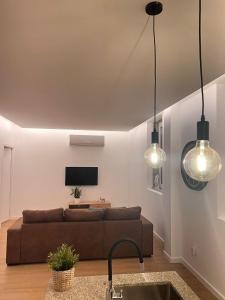 - un salon avec un canapé brun et deux lumières dans l'établissement Quinta Lourenca - Vila do Conde, à Vilar