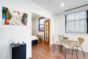 a room with a table and chairs and a bedroom at Cute & Cosy - Walk to City, Harbour and Museum in Sydney