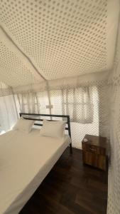 a bedroom with a white bed and a table at Sari Highlands in Sari