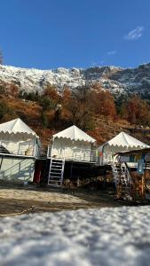 a group of white tents with snow on a hill at Sari Highlands in Sari