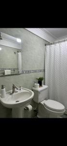 a bathroom with a white toilet and a sink at La casa de Maria in Santo Domingo