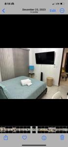 a picture of a bedroom with a bed and a tv at La casa de Maria in Santo Domingo