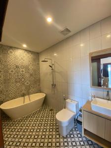 a bathroom with a tub and a toilet and a sink at The Ganesha Homestay in Canggu