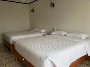 duas camas sentadas uma ao lado da outra num quarto em Edge Resort, Yogyakarta em Parangtritis