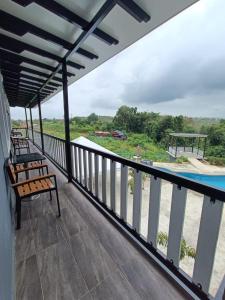 a balcony with a bench and a swimming pool at Perry Barr La Ganta Residence in Temerloh