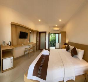 a large bedroom with a large bed and a desk at The Ganesha Homestay in Canggu